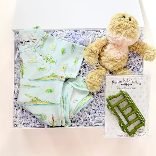 Baby gift set with teddy bear, blanket, and book on a textured surface