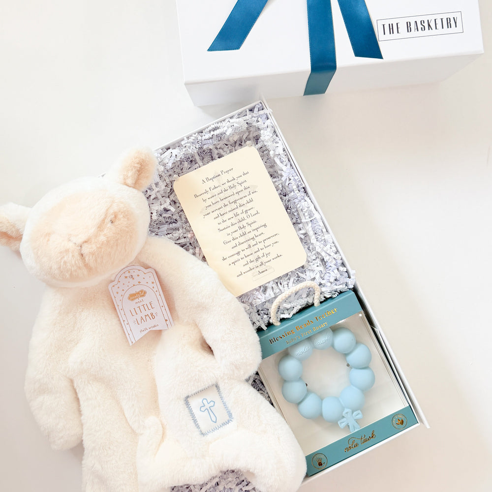 Baby gift set with teddy bear, card, and rattle on a white background