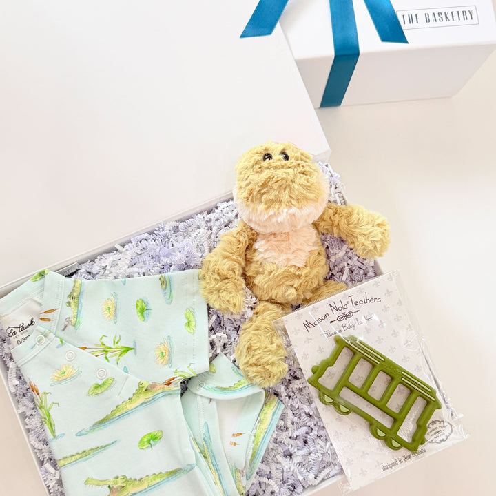 Baby gift set with onesies and a teddy bear in a box with a blue ribbon.