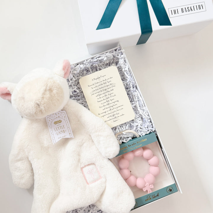 White teddy bear, baby rattle, and gift card in a box with a white background