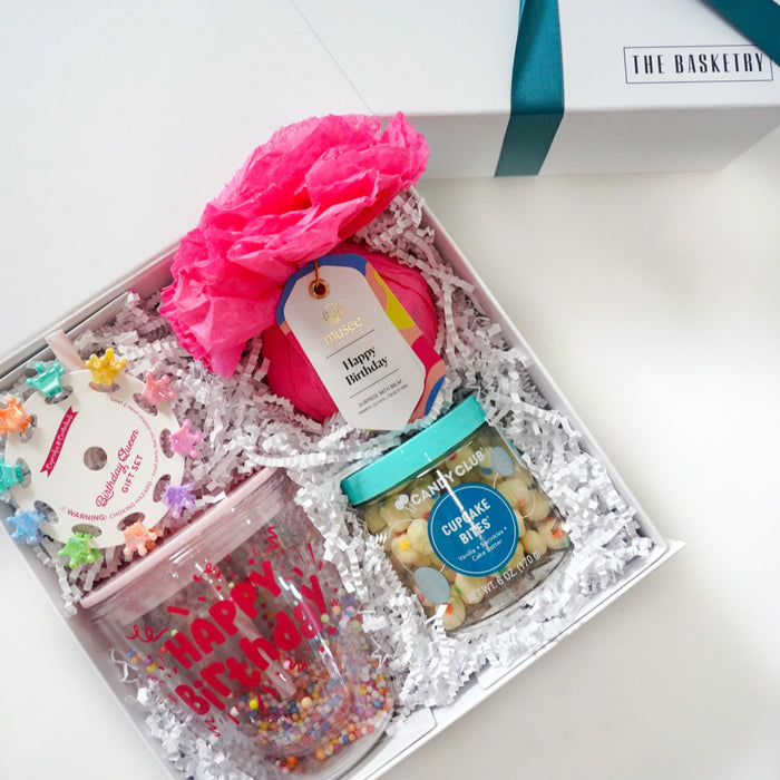 Gift box with colorful contents and a blue ribbon on a white background
