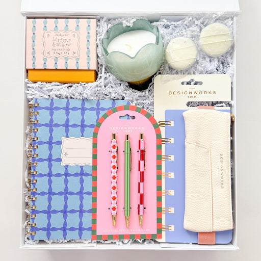 Stationery set with a notebook, pen, and other items in a box on a white background