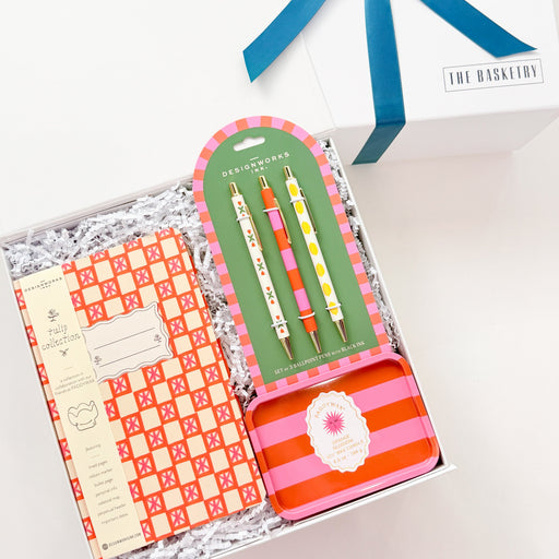 Set of stationery items including a notebook, pen, and stickers in a clear box with a blue ribbon on a white background.