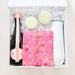 Gift set with champagne bottle, chocolates, and pink box on a white background