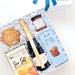 A gourmet gift hamper from The Gift Basket, featuring a bottle of Chandon sparkling wine, a box of Peruvian Huirse Salt, a bar of Pecan Caramel Brownie, and a chocolate-covered biscuit, arranged in white crinkle paper inside a white gift box with a blue ribbon.
