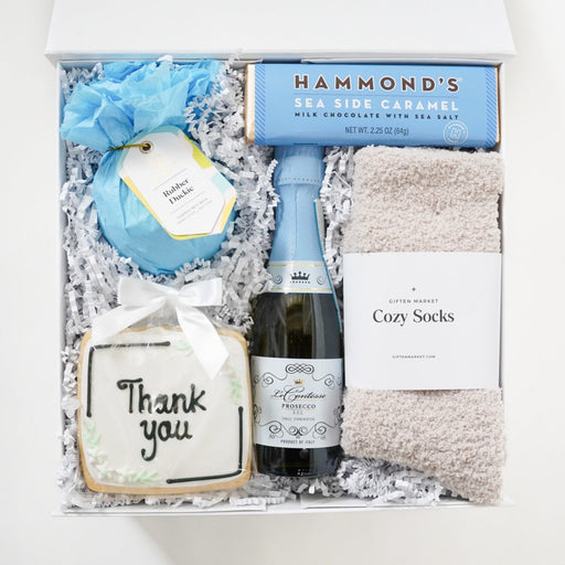 Gift set with bottle, card, and other items in a box