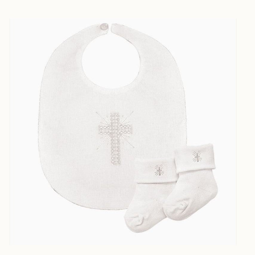Product photograph of a white cotton Christening set featuring a baby bib and matching socks displayed on a plain background with an intricate shimmering beaded cross and small embroidered religious motifs on the folded cuffs