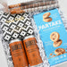 Gift set with 'Barker' coffee cans and 'Partake' cookies in a decorative box.