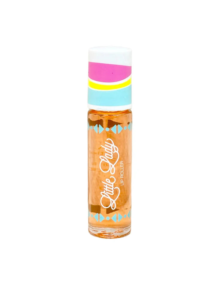 Studio photograph by Little Lady of a Lip Roller on a white background featuring peach-tinted oil, a white cap with pink, yellow, and blue stripes, and a white script logo framed by blue geometric accents