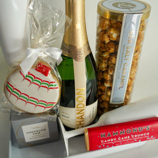 Bottle of Chandon champagne with a cookie, popcorn, and candy on a tray.