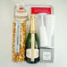 Bottle of champagne with a bag of sea salt caramel popcorn and a box of chocolate crisps on a white surface.
