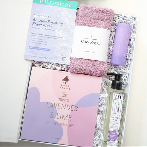 Gifting set with bath products including a bottle, soap, and towel on a white background.