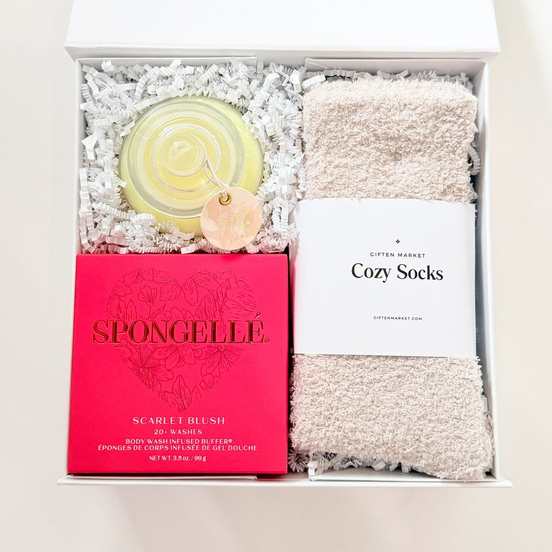 Gift set with a bar of soap, towel, and product packaging on a white background