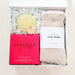 Gift set with a bar of soap, towel, and product packaging on a white background