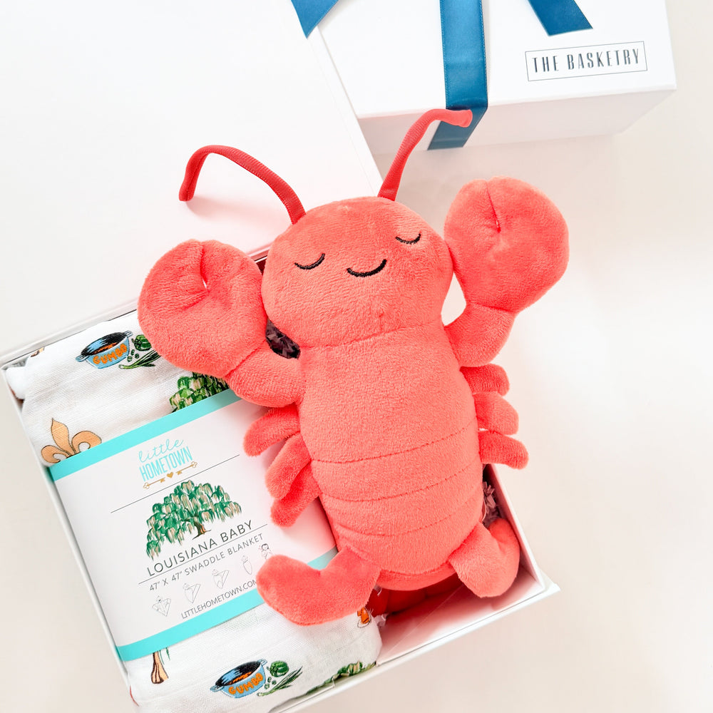 Plush lobster toy with a blue ribbon on a white background