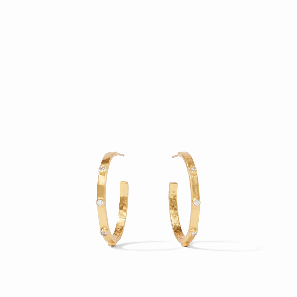 Gold plated Julie Vos hoop earrings featuring a hammered metal texture and bezel-set clear crystals on a white studio background