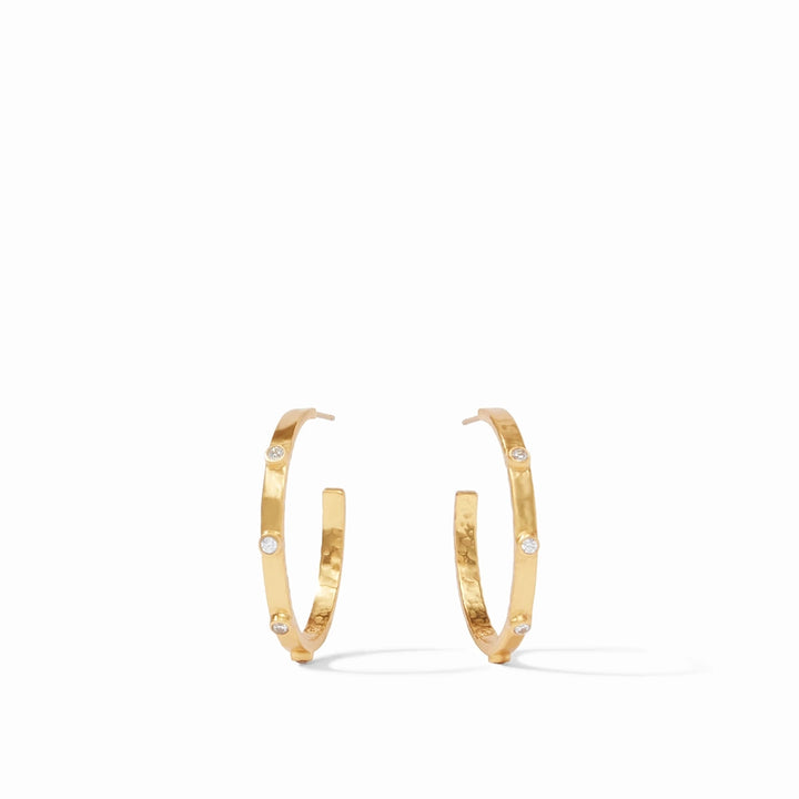 Gold plated Julie Vos hoop earrings featuring a hammered metal texture and bezel-set clear crystals on a white studio background