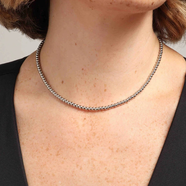 Digital photograph of a silver beaded necklace worn on a woman&