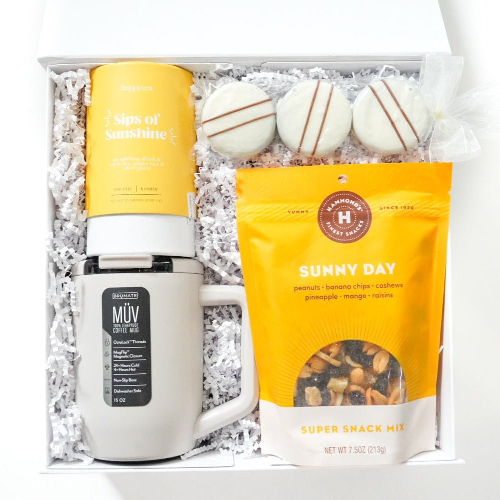 Gift set with mug, snacks, and bath bombs on a white background