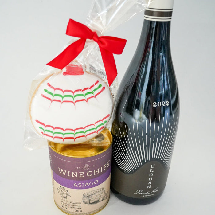 Bottle of wine, bag of wine chips, and decorative item on a white background