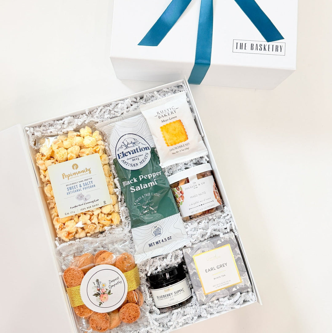 Gift box with snacks and a blue ribbon on a white background