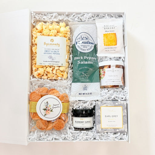 Gift box with assorted snacks and products on a white background