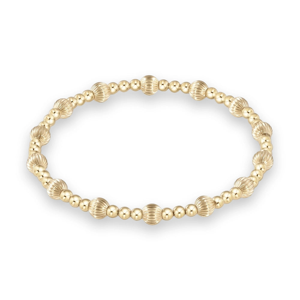Gold-filled beaded stretch bracelet centered on a white background featuring a repeating pattern of high-polish smooth spheres and larger vertically ribbed fluted accents