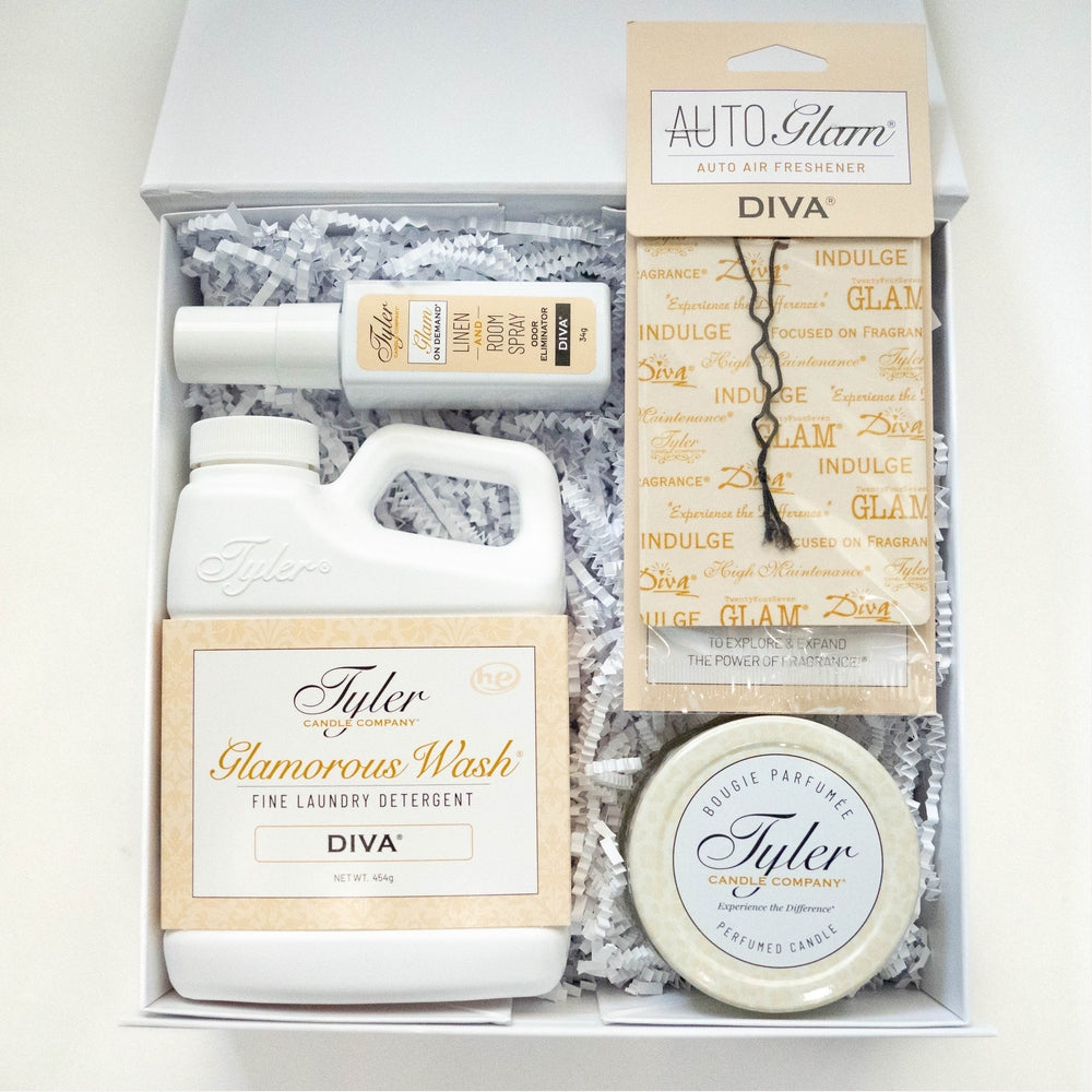 Product photograph of a Tyler Candle Company Diva fragrance gift box featuring the iconic Glamorous Wash detergent, room spray, and a perfumed candle displayed on white shredded paper with elegant gold and ivory packaging
