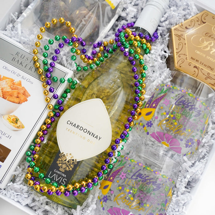 Unopened bottle of Chardonnay with decorative beads and a glass in a gift box.