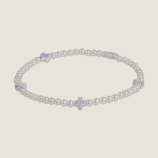 Silver-tone beaded bracelet centered on a light grey background featuring four equidistant polished cross charms and uniform metallic round beads with a reflective finish