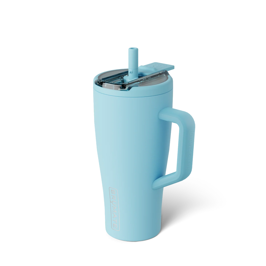 Product photograph by BrüMate of a sky blue insulated Era tumbler featuring the iconic embossed logo, a matching silicone straw, and a clear leak-proof lid on a white background