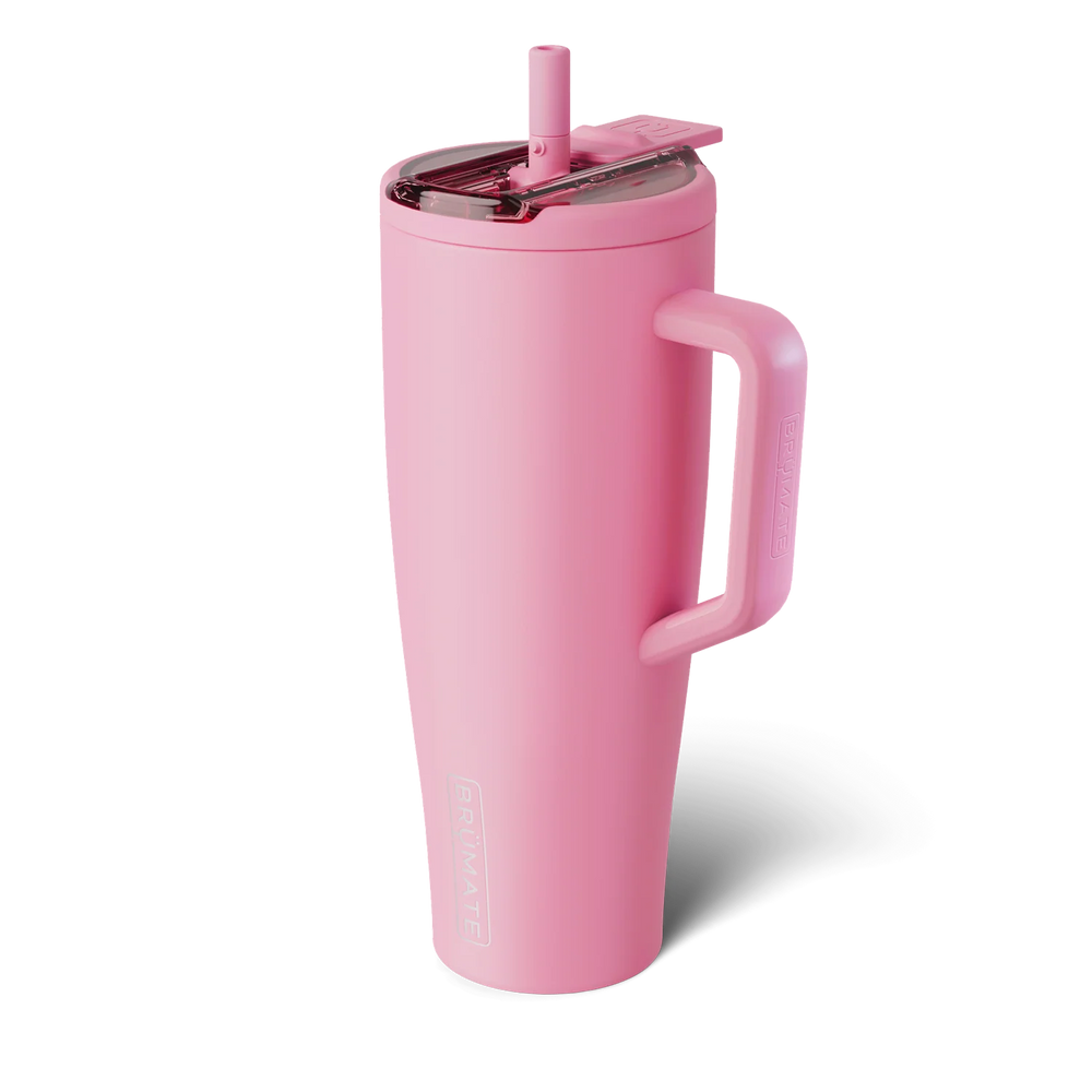 Product photograph of a BrüMate Era tumbler against a neutral background featuring a vibrant matte pink finish, a translucent lid with a matching straw, and a large side handle with the brand's signature embossed logo