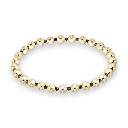 Fine jewelry product photograph of a beaded bracelet on a white background featuring large polished yellow gold spheres alternating with small faceted black beads and a reflective high-shine finish