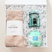 Gift set with socks, candle, and bath bomb in a box on a white background