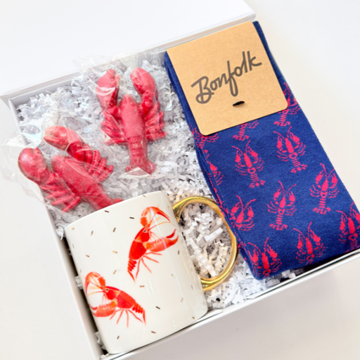 Box with lobster-themed items including socks, a mug, and a candle.
