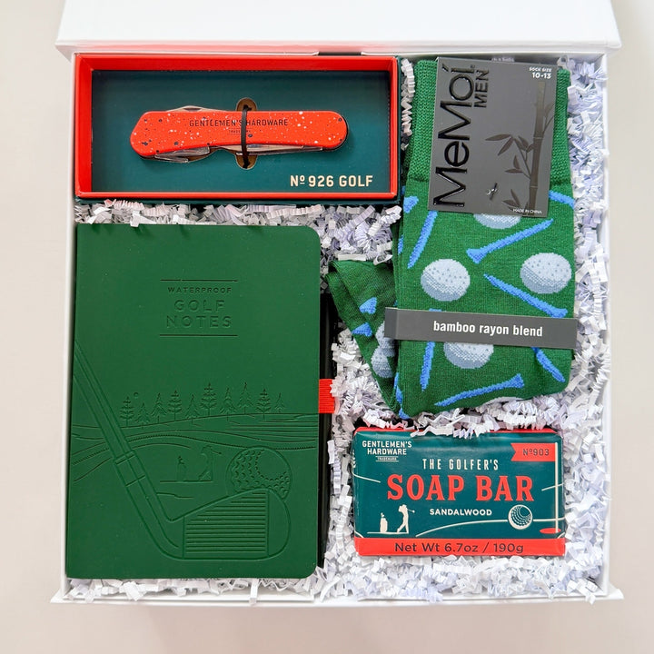 Grooming kit with green book, red tool, and soap bar in a box on a white background