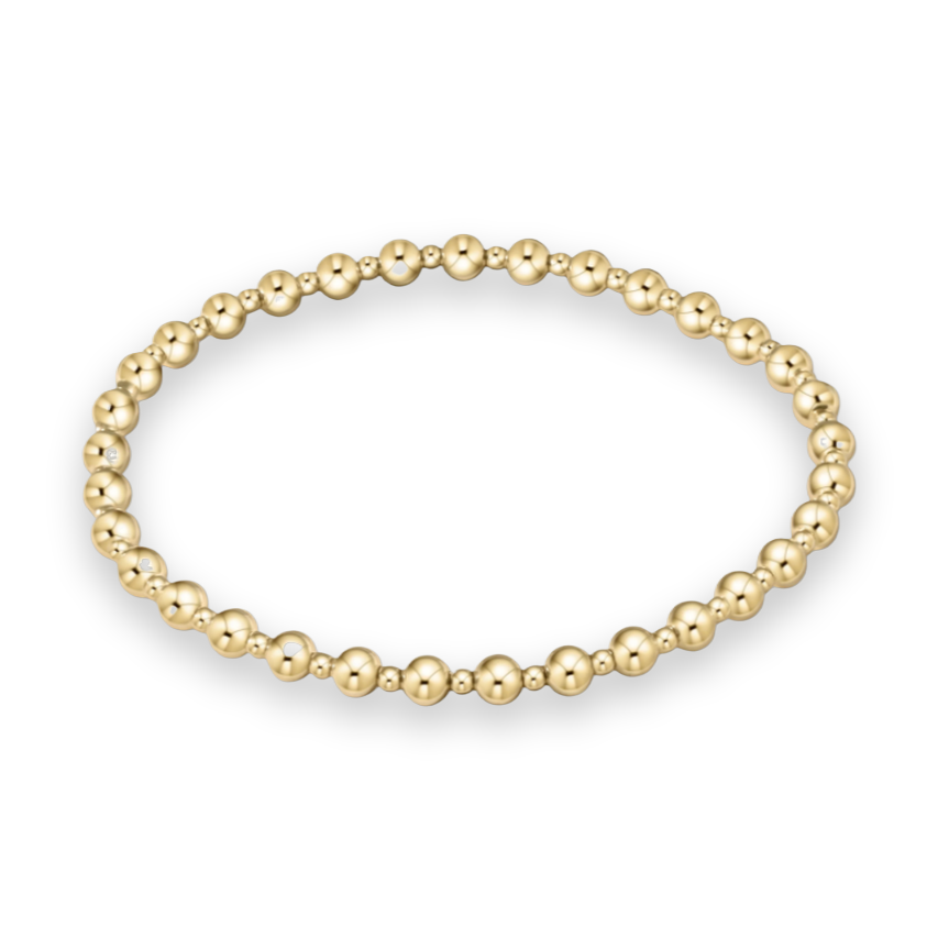 Gold jewelry beaded bracelet featuring alternating high-polish large and small spherical beads in a brilliant gold tone arranged in a circular shape against a white background
