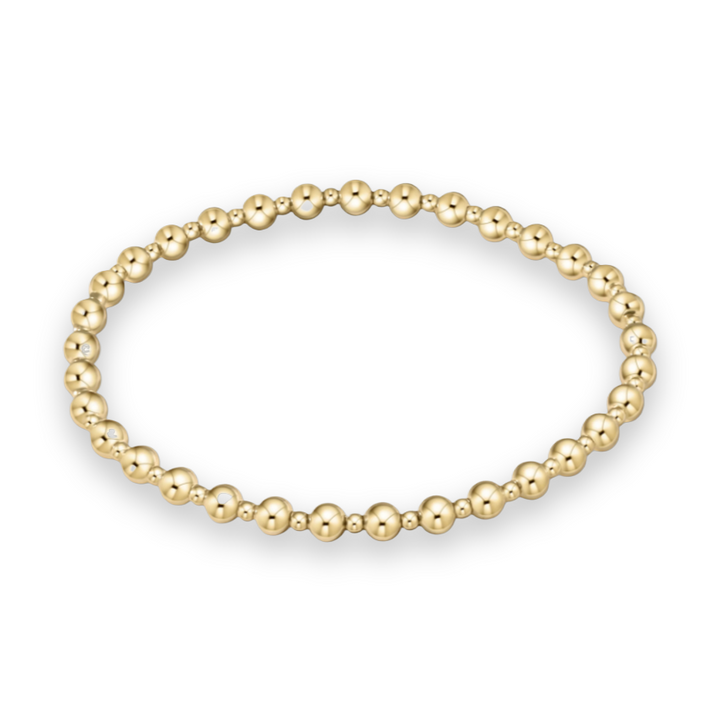 Gold jewelry beaded bracelet featuring alternating high-polish large and small spherical beads in a brilliant gold tone arranged in a circular shape against a white background