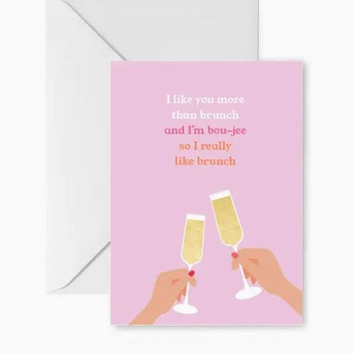 Stationery greeting card featuring two hands with red nail polish toasting with champagne flutes against a pastel pink background with the playful text I like you more than brunch and I'm bou-jee so I really like brunch