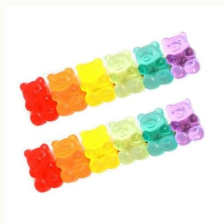 Studio photograph of multicolored gummy bear candies arranged in two parallel diagonal rows on a white background featuring translucent gelatinous textures and a vibrant rainbow spectrum of colors