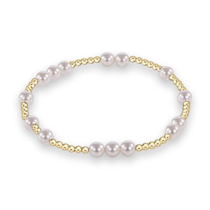 Studio photograph of a beaded bracelet featuring lustrous white pearls and polished yellow gold spherical beads in a rhythmic alternating pattern set against a solid white background