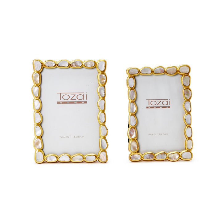 Handcrafted brass and mother-of-pearl picture frames by Tozai Home featuring two rectangular photo holders with iridescent shell inlays and organic gold scalloped borders on a white background