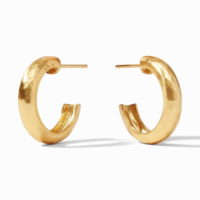 Gold-toned metal chunky open hoop earrings featuring a hand-hammered texture and thick tubular silhouette set against a neutral white background