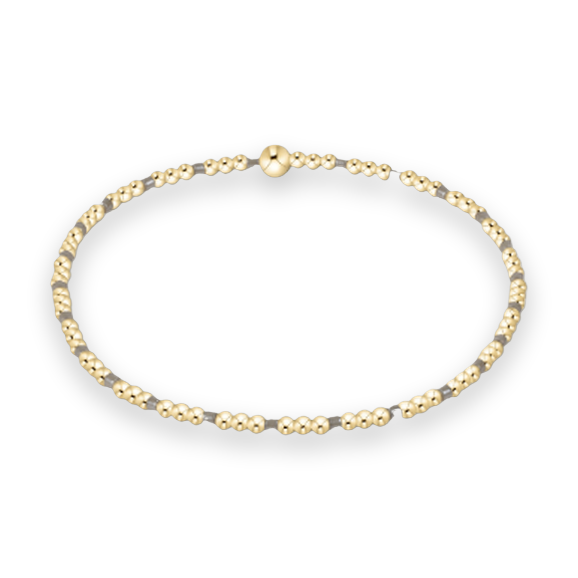 Gold beaded bracelet jewelry showcasing a delicate pattern of polished gold-filled spheres and alternating grey accent beads with a larger central gold bead on a white studio background
