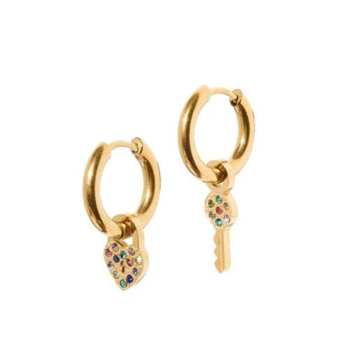 Gold-toned jewelry featuring a pair of hoop earrings with heart-shaped padlock and key charms embellished with vibrant multi-colored rainbow stones on a white background