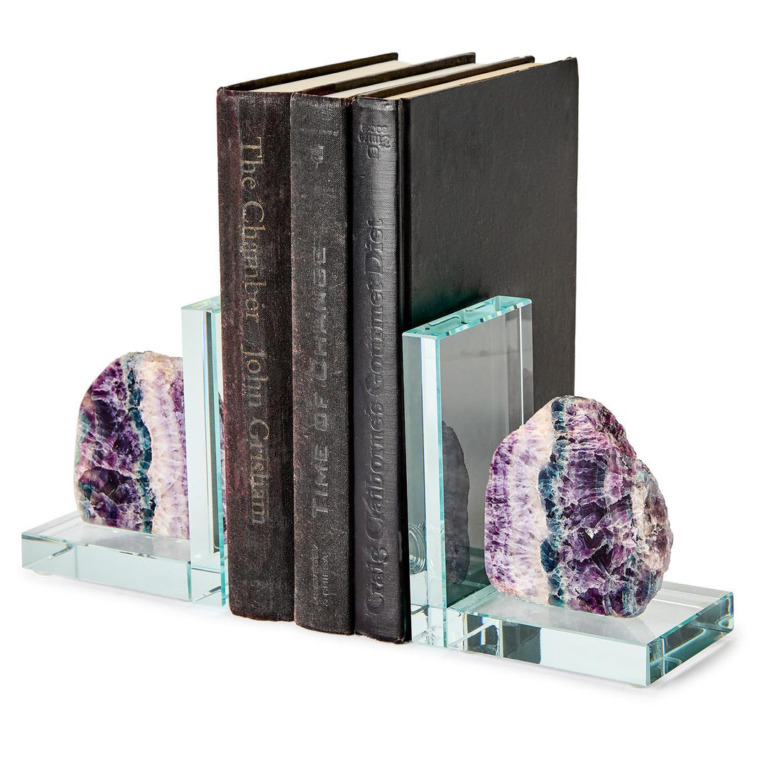 Handcrafted amethyst and glass bookends holding three vintage books including The Chamber by John Grisham on a white background, featuring jagged purple crystals with teal mineral bands and transparent L-shaped glass bases