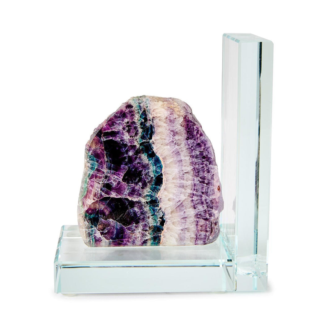 Natural fluorite crystal bookend mounted on a clear glass base featuring vibrant purple and teal banding with a jagged crystalline texture against a white studio background