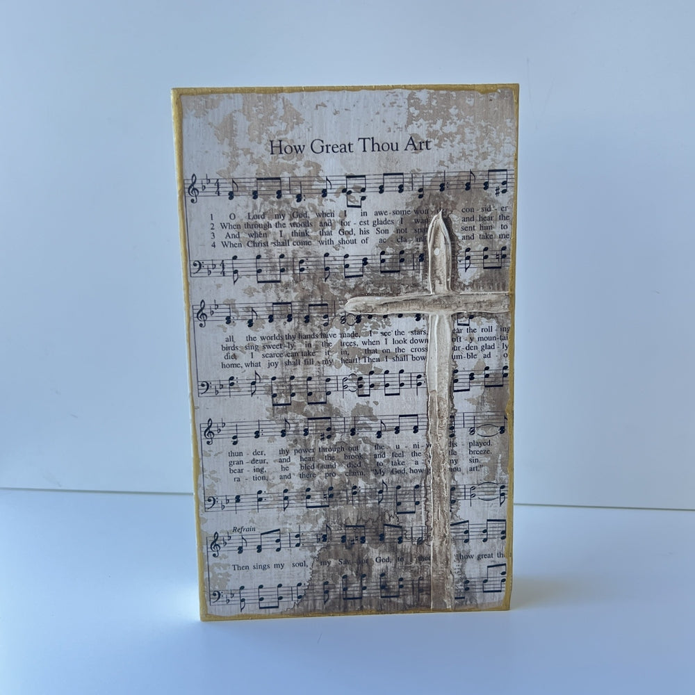 Mixed media wood block art featuring the hymn How Great Thou Art on a minimalist white background, highlighting a raised three-dimensional Christian cross, weathered sepia distressing, and a shimmering gold border