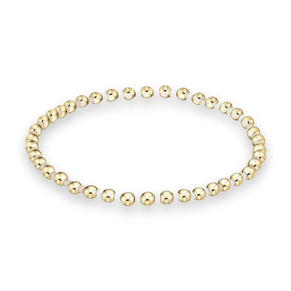 Beaded gold bracelet jewelry on a white background featuring polished yellow-gold spheres and small cream-colored spacers in a seamless circular design