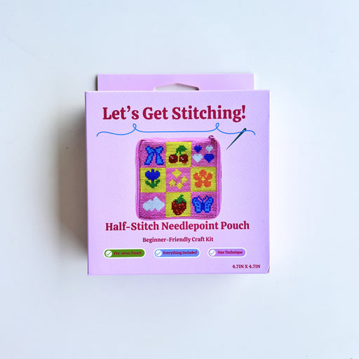 A pink retail box for a 'Let's Get Stitching! Half-Stitch Needlepoint Pouch' craft kit, photographed against a plain white background.